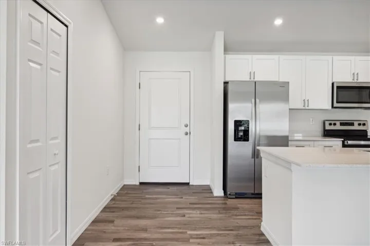 Kitchen featuring white cabinetry, hardwood / wood-style floors, and stainless steel appliances