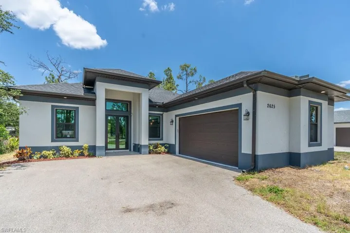 Prairie-style house featuring stucco siding, a garage, and asphalt driveway