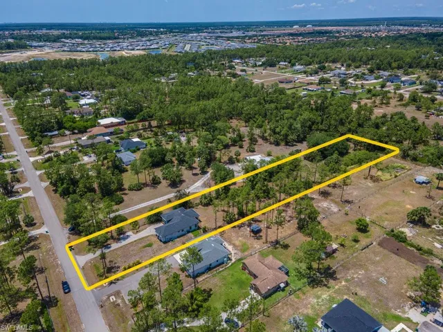 Aerial view of property and surrounding area with property parcel outlined