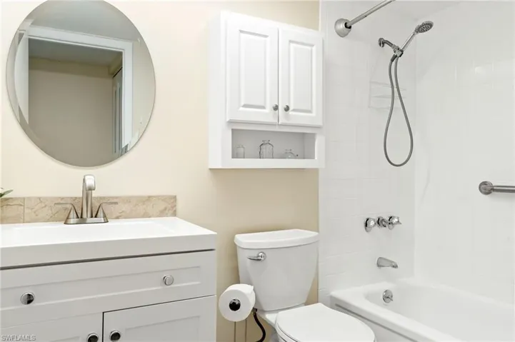 Full bathroom featuring tiled shower / bath, toilet, and vanity