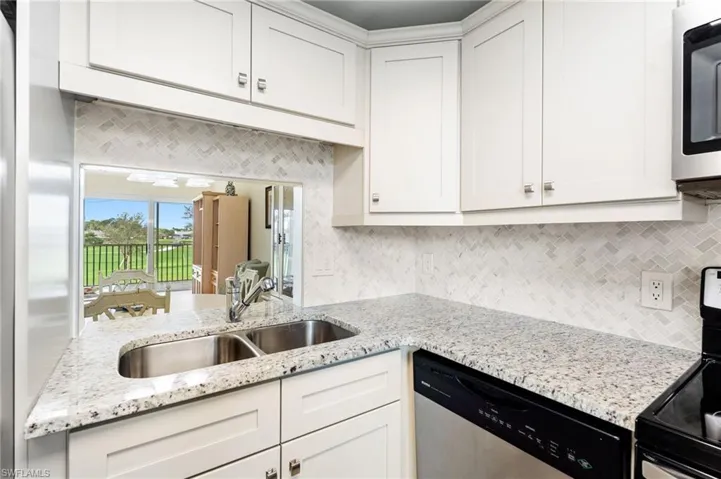 Kitchen with white cabinets, decorative backsplash, dishwasher, sink, and electric range