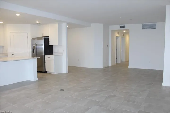 Unfurnished living room with baseboards, visible vents, and recessed lighting