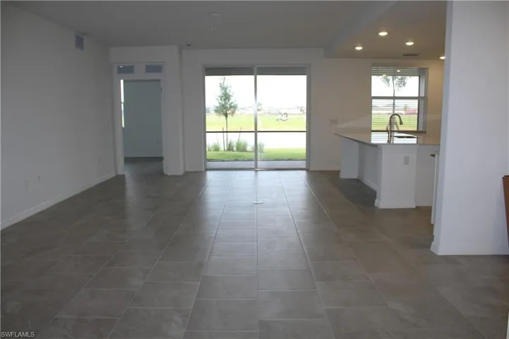 Spare room featuring tile patterned floors, a sink, baseboards, and recessed lighting