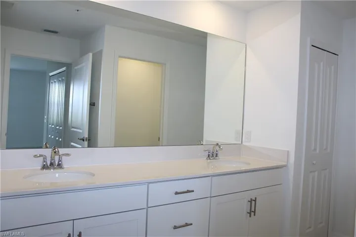 Master bath with double vanity, visible vents, and a sink