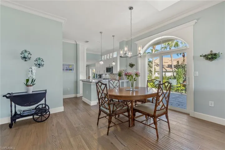 Dining space with a chandelier, light hardwood / wood-style floors, and ornamental molding