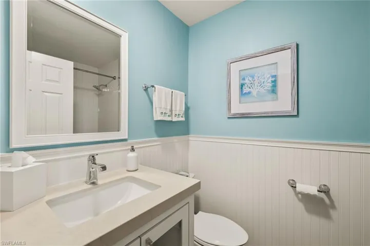 Bathroom featuring a tile shower, vanity, and toilet