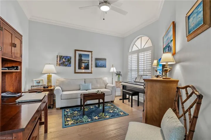 Living room featuring light hardwood / wood-style flooring, ceiling fan, and crown molding