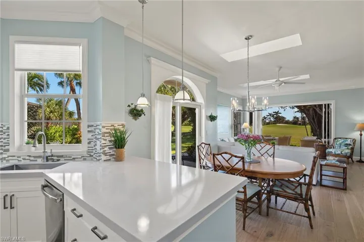 Kitchen featuring backsplash, white cabinets, crown molding, sink, and light hardwood / wood-style flooring