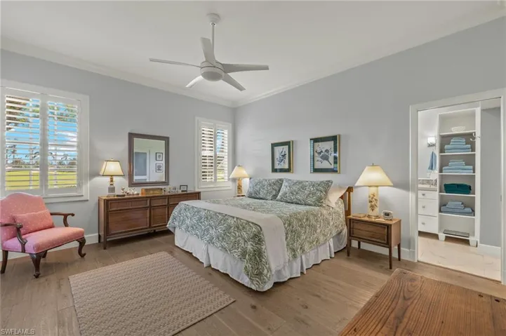 Bedroom featuring hardwood / wood-style flooring, ceiling fan, and crown molding