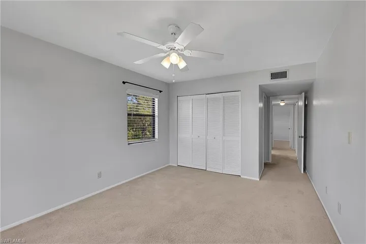 Unfurnished bedroom with light colored carpet, a closet, and ceiling fan