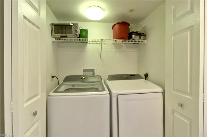 Washroom with washer and clothes dryer