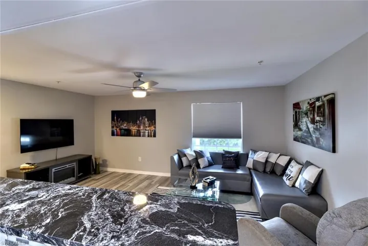 Living room with ceiling fan and light hardwood / wood-style floors