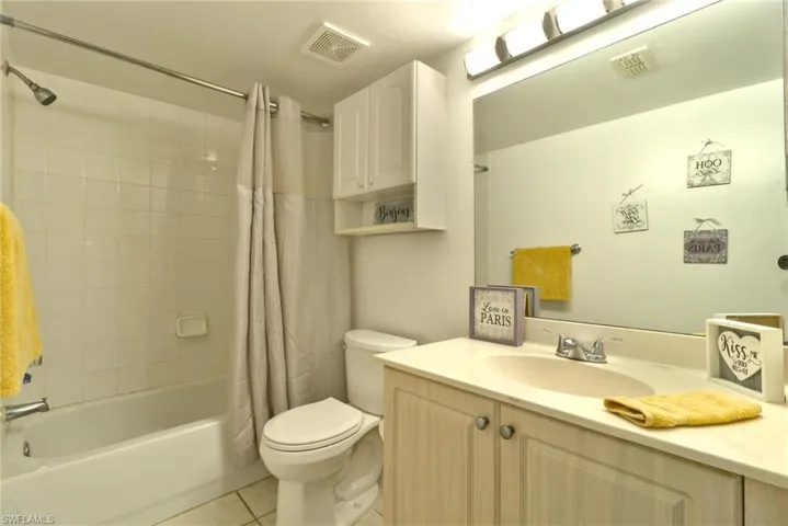 Full bathroom featuring shower / bath combo, toilet, tile patterned flooring, and vanity