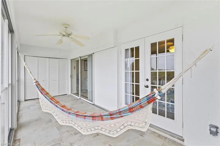 Unfurnished sunroom with ceiling fan and a patio area