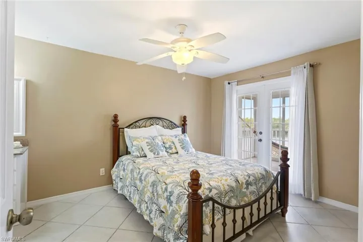 Bedroom with french doors, light tile patterned floors, access to exterior, and a ceiling fan