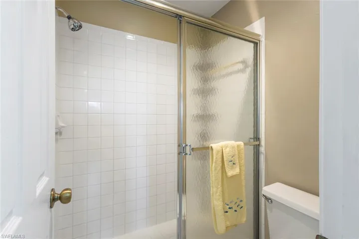 Full bath featuring a stall shower and toilet