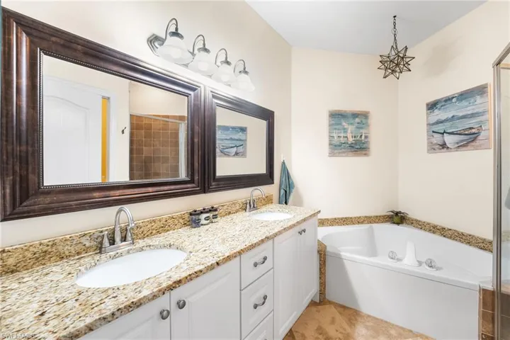 The ensuite bathroom has dual granite countertop vanity, soaking tub and a walk in shower. Beautiful wood framed mirrors.