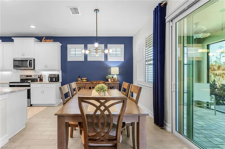 Open-concept kitchen and dining area featuring clean white cabinetry and a contrasting accent wall
