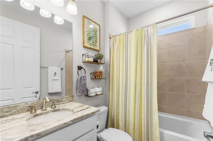 Bathroom featuring a vanity with a light-toned countertop, undermount sink, and brushed nickel faucet