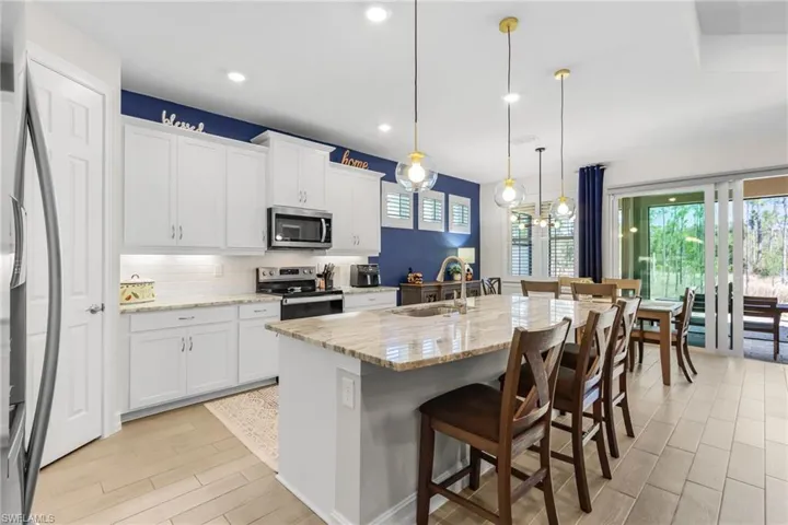 Contemporary kitchen featuring white cabinetry, light-toned countertops, and a subway tile backsplash
