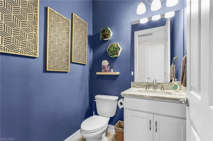 Bathroom featuring a white vanity with a stone countertop and an undermount sink