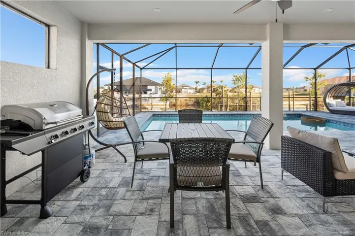 View of patio / terrace with a lanai, grilling area, and ceiling fan