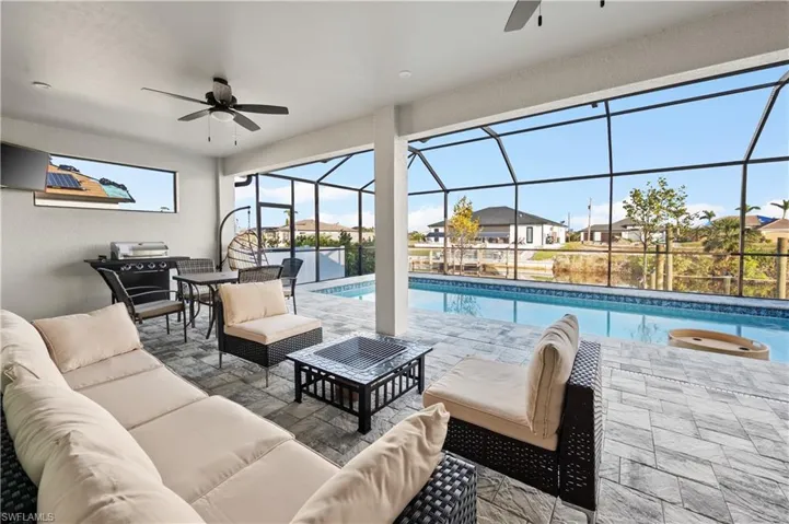 View of pool featuring an outdoor living space, ceiling fan, a lanai, and a patio