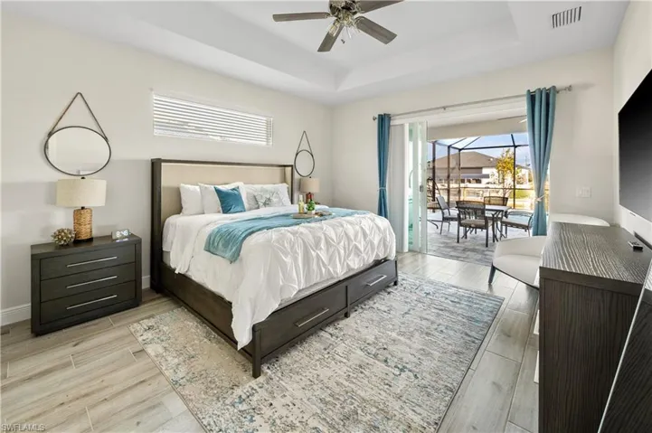 Bedroom with a tray ceiling and ceiling fan