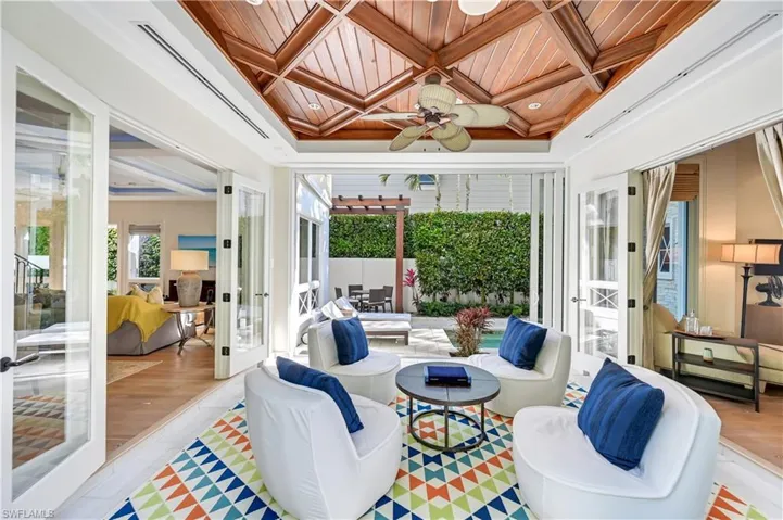 Sunroom with coffered ceiling, wooden ceiling, french doors, and crown molding
