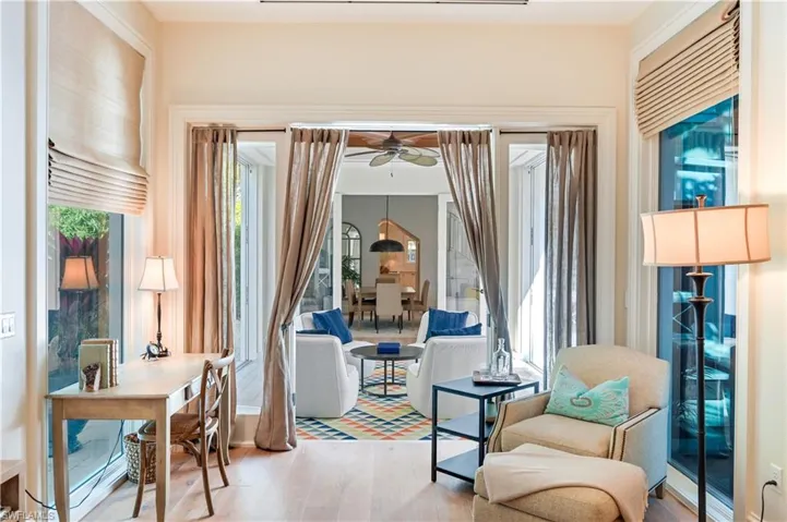 Sitting room with light wood-type flooring and a ceiling fan
