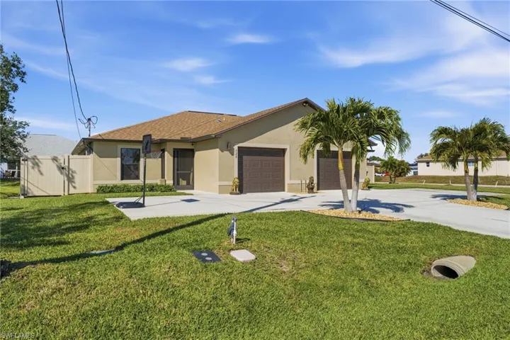 Ranch-style house with a front yard, stucco siding, concrete driveway, and a garage