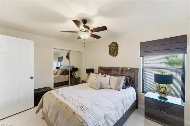 Bedroom with multiple windows, ceiling fan, a closet, and light tile patterned flooring