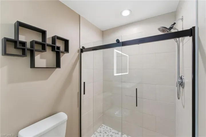 Full bathroom with toilet and a stall shower