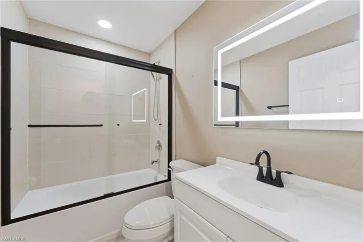 Full bath featuring vanity and enclosed tub / shower combo
