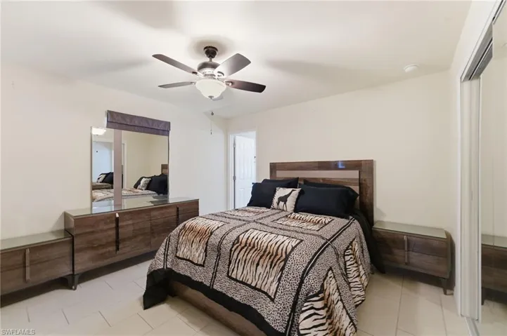 Bedroom with ceiling fan, a closet, and tile patterned floors