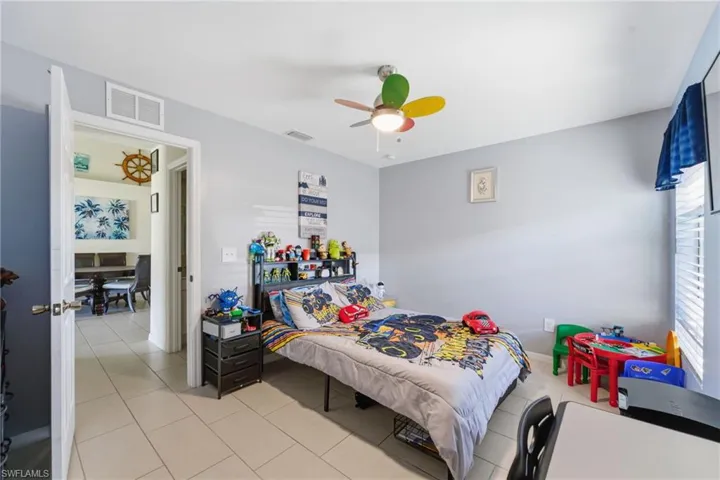Bedroom with a ceiling fan and light tile patterned flooring