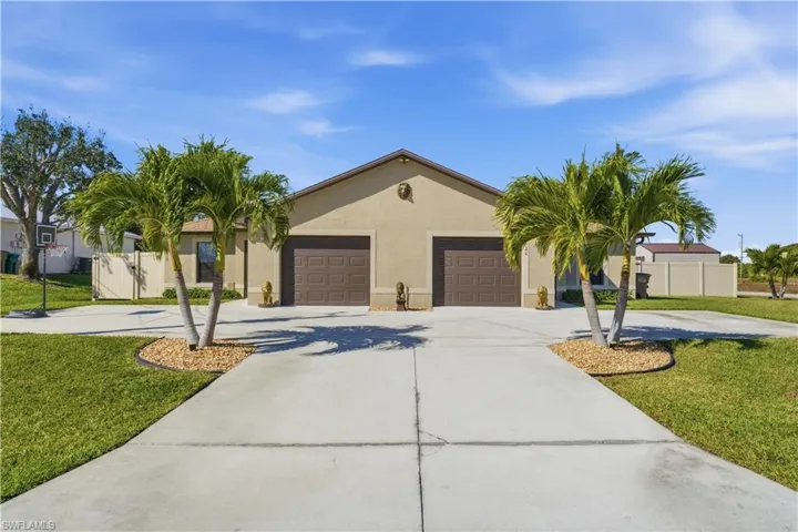 View of front of house with driveway, stucco siding, and an attached garage
