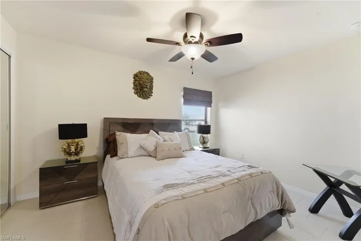 Bedroom featuring a ceiling fan, a closet, and light tile patterned floors