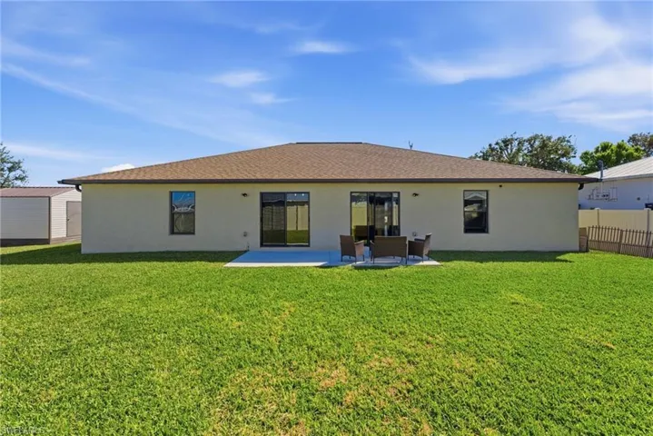Back of house with a patio, stucco siding, and a shingled roof