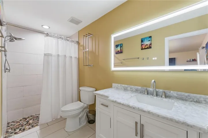 Bathroom with a shower stall, vanity, and light tile patterned floors