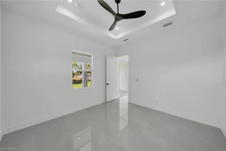 Spare room with recessed lighting, ceiling fan, and a tray ceiling