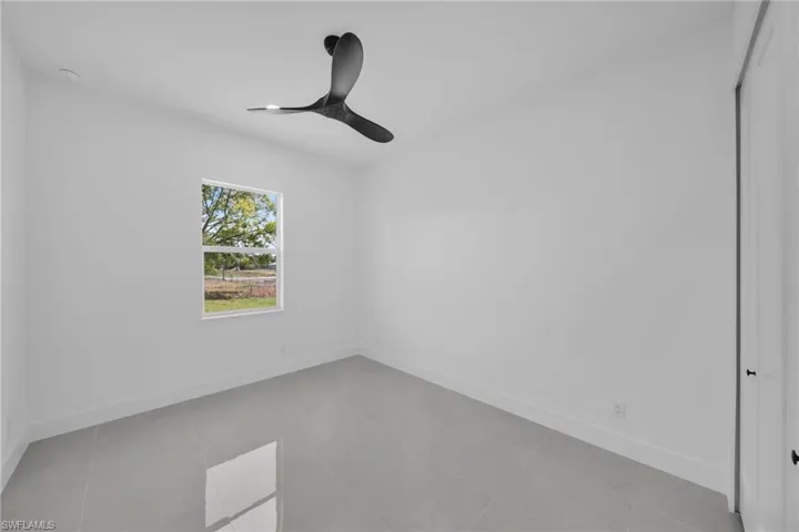 Spare room featuring a ceiling fan and light tile patterned floors