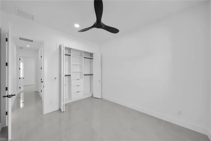 Unfurnished bedroom featuring a closet, a ceiling fan, recessed lighting, and light tile patterned floors