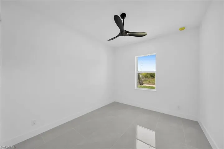 Unfurnished room with baseboards and ceiling fan