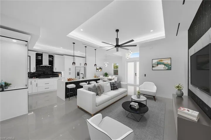 Living area featuring recessed lighting, a ceiling fan, and a raised ceiling