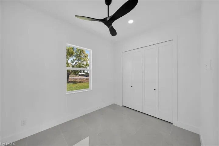 Unfurnished bedroom with a ceiling fan, a closet, recessed lighting, and light tile patterned flooring