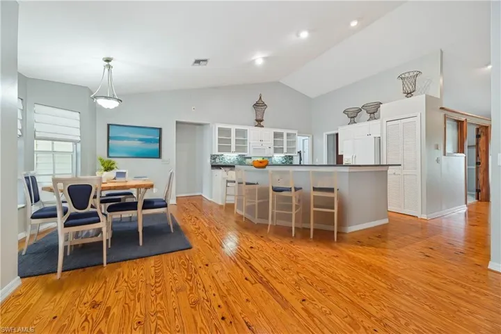 Dining room with light wood-type flooring and lofted ceiling