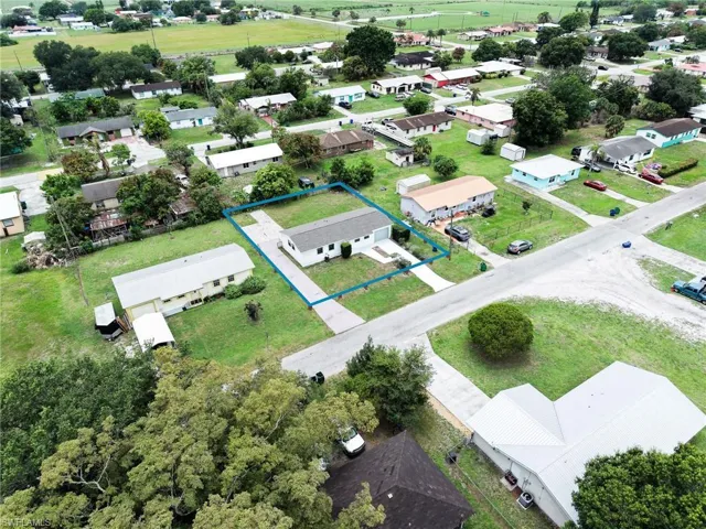 Aerial perspective showcasing a single-story residence with a light-colored roof and an attached garage