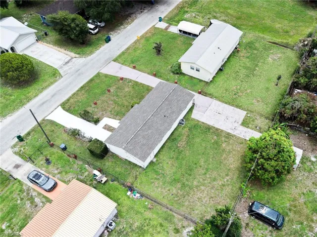 Aerial perspective showcasing a property with a light-colored exterior and a gray shingle roof