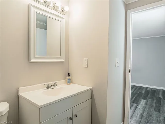 Bathroom vanity featuring a white cabinet, integrated sink, and chrome faucet